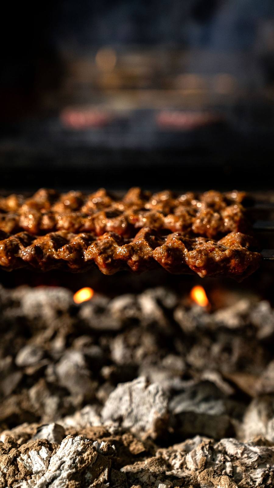 Kebabs over live coals at a counter